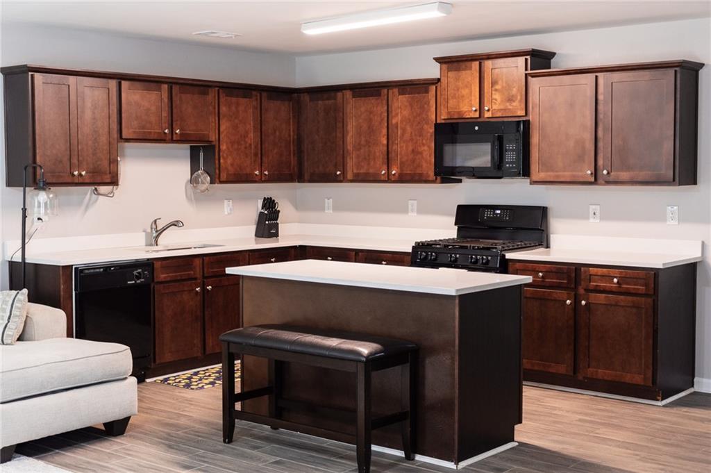 165 Pine Ridge Road Covington, GA 30016 - Photo 7 of 28 a kitchen with a sink cabinets and black appliances