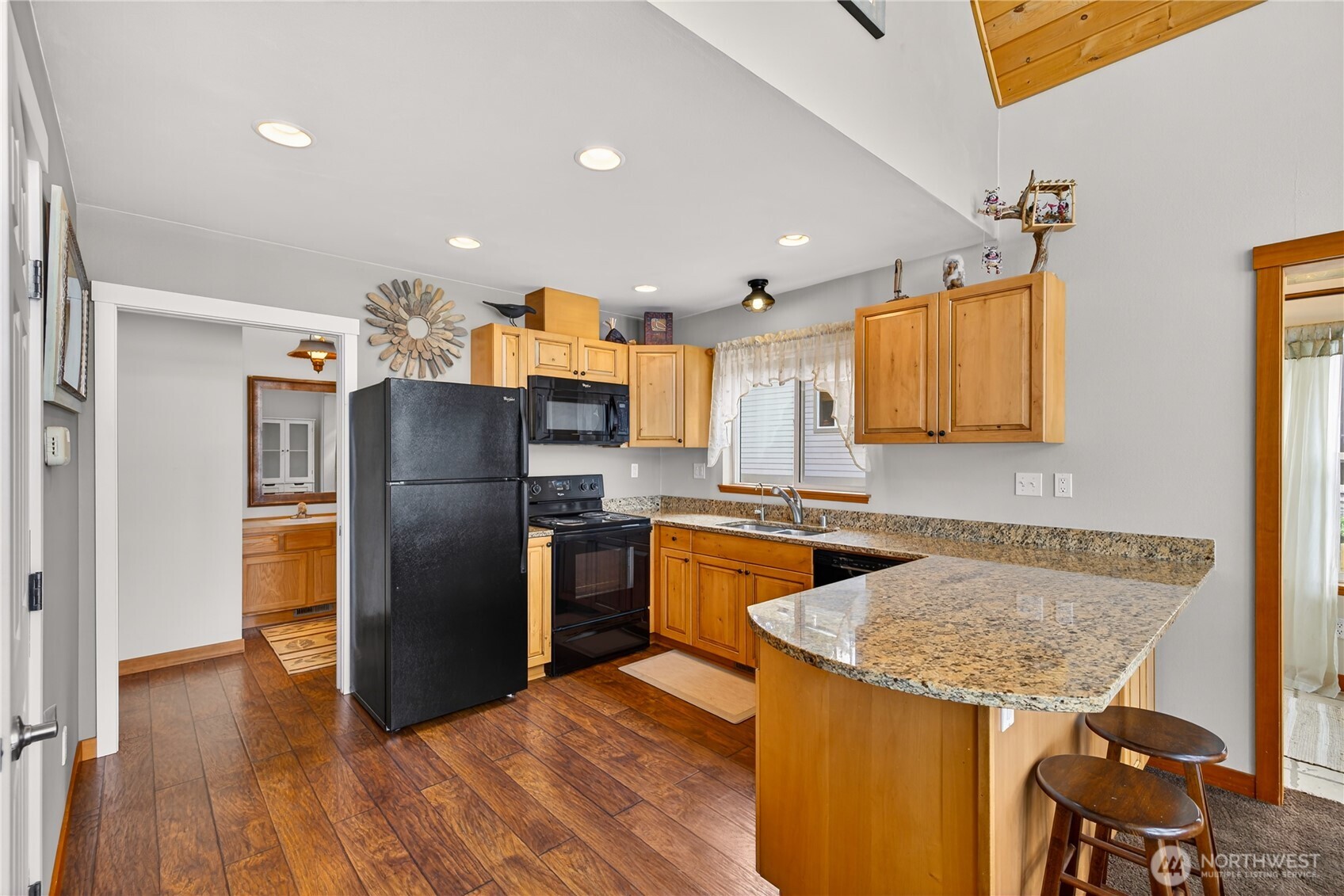 17946 Cobahud Road La Conner, WA 98257 - Photo 25 of 40 a kitchen with stainless steel appliances granite countertop a refrigerator a sink dishwasher a stove with wooden cabinets and floor