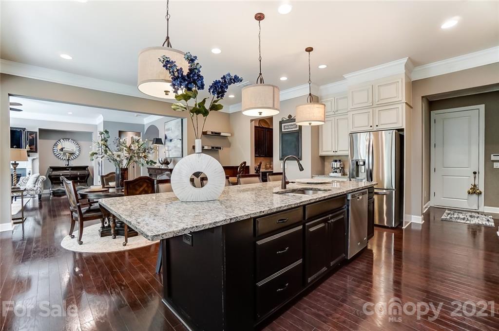 1362 Afton Way Fort Mill, SC 29708 - Photo 17 of 48 a kitchen with kitchen island granite countertop a stove a refrigerator a oven a dining table and chairs with wooden floor