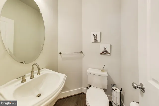 a bathroom with a sink mirror and toilet