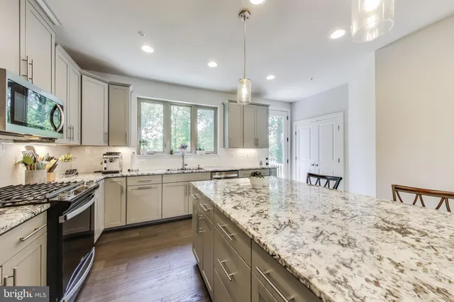 a kitchen with stainless steel appliances granite countertop sink stove and granite counter top