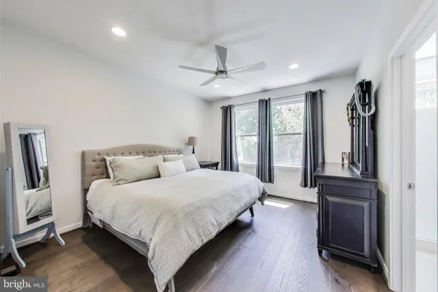 a bedroom with a large bed a flat tv screen and dresser