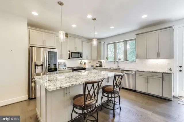 a kitchen with stainless steel appliances granite countertop refrigerator stove microwave and cabinets