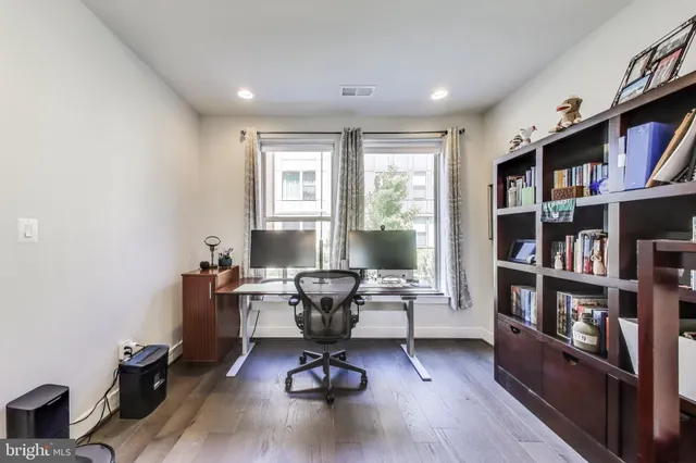 a view of a workspace with furniture and a bookshelf