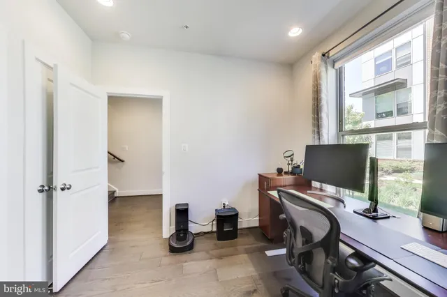 a view of a workspace with furniture and a window