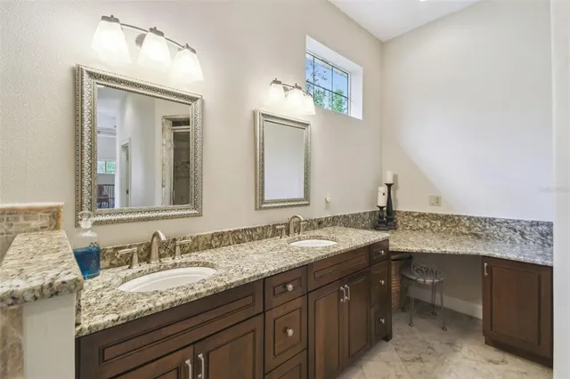 a bathroom with a granite countertop toilet a sink and a mirror