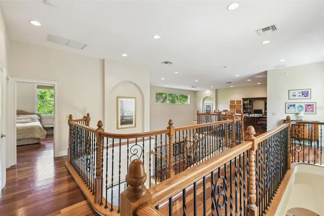 a view of a hallway with wooden floor and windows