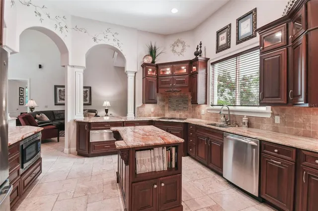 a kitchen with stainless steel appliances granite countertop a stove a sink and a refrigerator