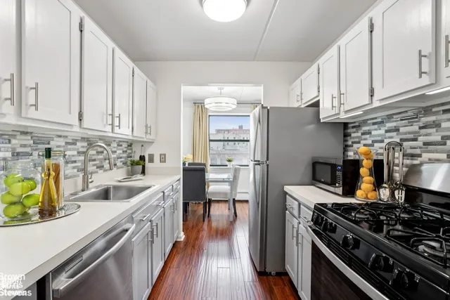 a kitchen with granite countertop a sink a stove and wooden cabinets