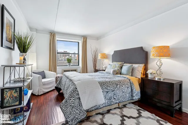 a bedroom with a bed a couch and a potted plant