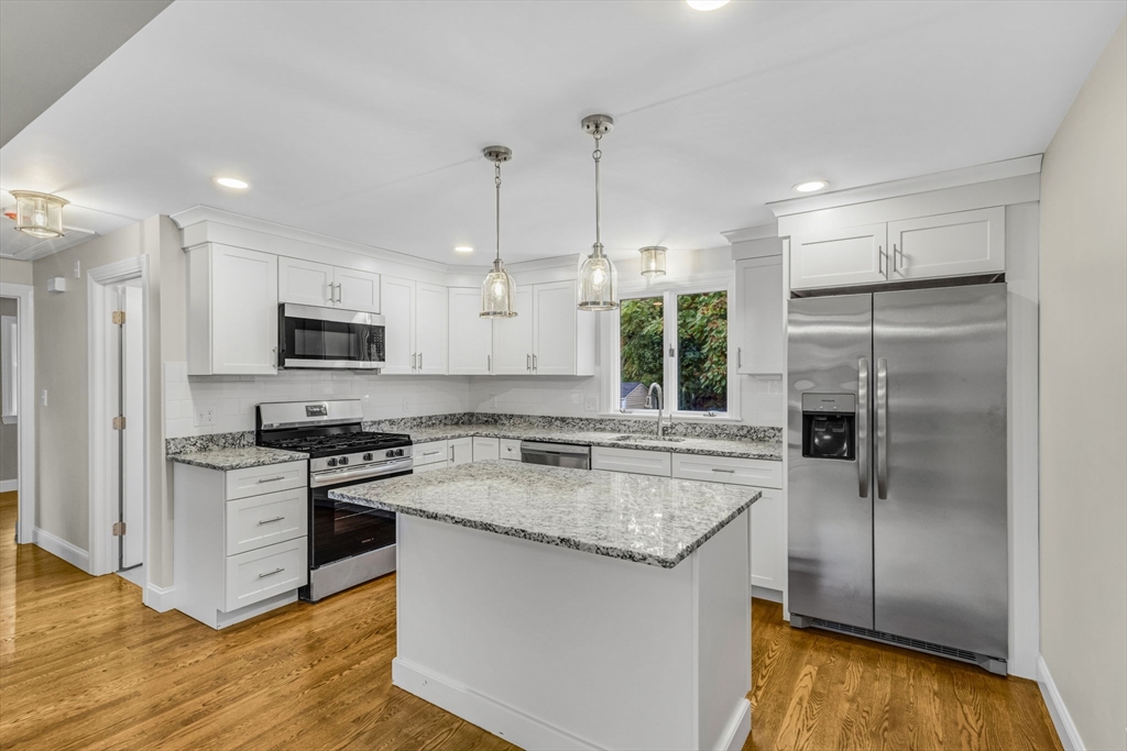 26 Navy Yard Road Dracut, MA 01826 - Photo 18 of 39 a kitchen with stainless steel appliances granite countertop a refrigerator a sink a stove a microwave and wooden floor