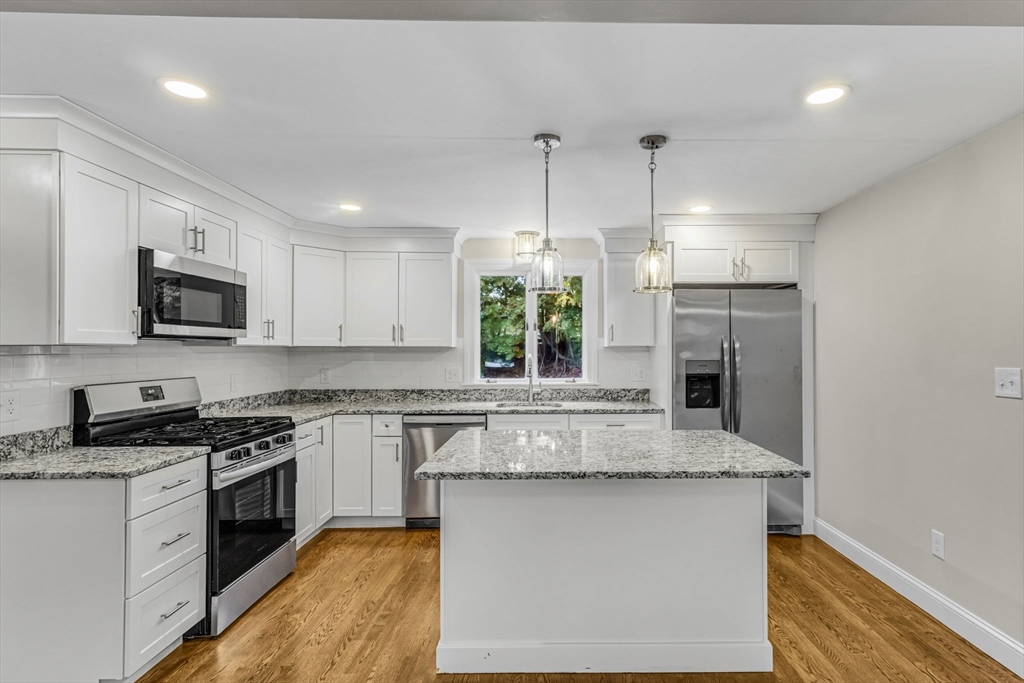 26 Navy Yard Road Dracut, MA 01826 - Photo 19 of 39 a kitchen with stainless steel appliances granite countertop a sink stove and refrigerator