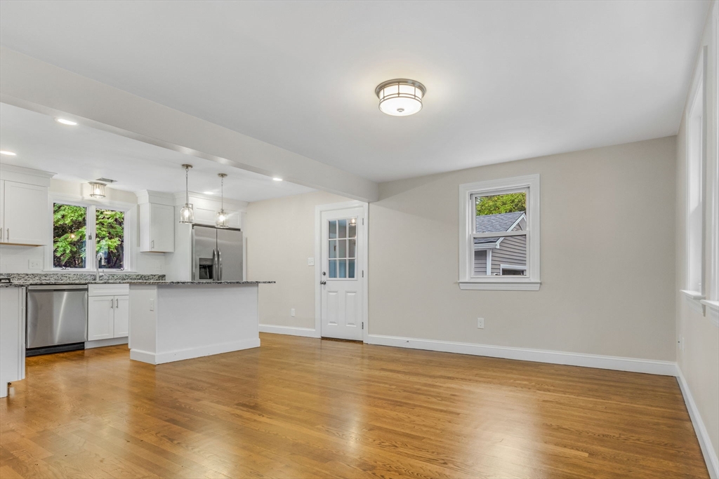 26 Navy Yard Road Dracut, MA 01826 - Photo 20 of 39 a view of a kitchen with kitchen island a sink wooden floor and a large window
