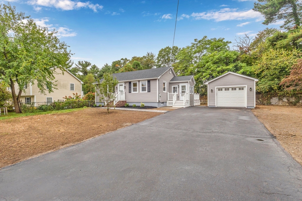 26 Navy Yard Road Dracut, MA 01826 - Photo 2 of 39 a front view of a house with a garden and trees