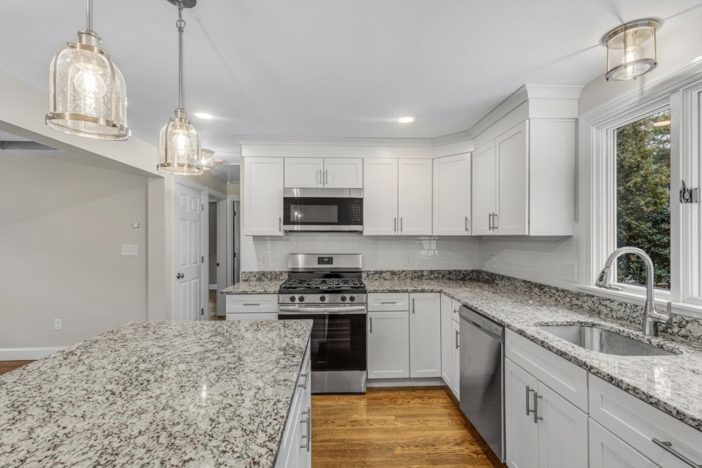 26 Navy Yard Road Dracut, MA 01826 - Photo 22 of 39 a kitchen with stainless steel appliances granite countertop a sink stove and refrigerator