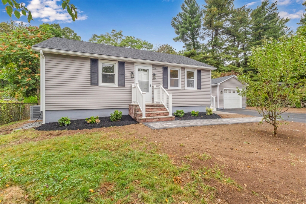 26 Navy Yard Road Dracut, MA 01826 - Photo 3 of 39 a front view of a house with a yard and garage