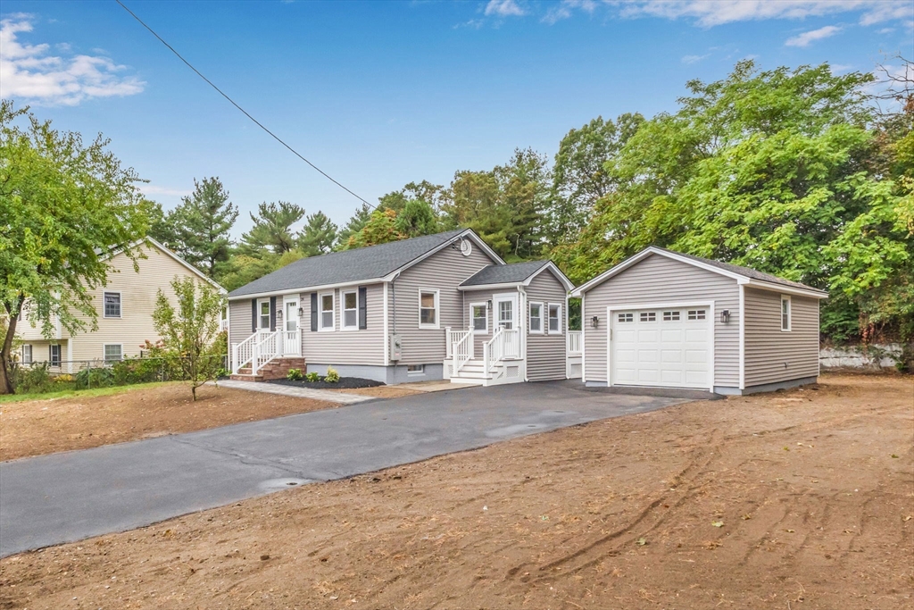 26 Navy Yard Road Dracut, MA 01826 - Photo 5 of 39 a front view of a house with a yard and garage