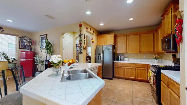 a kitchen with stainless steel appliances granite countertop a sink dishwasher stove and refrigerator