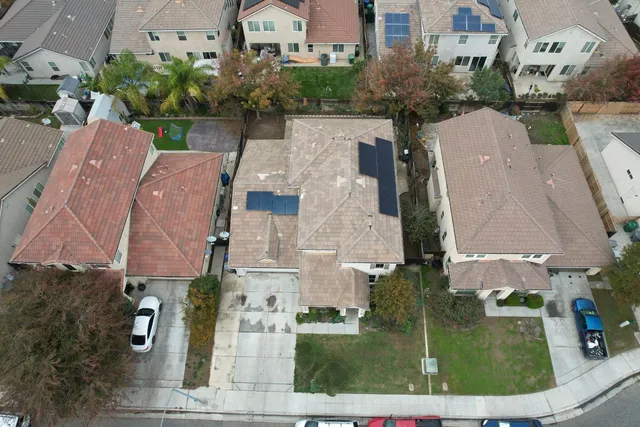 an aerial view of residential houses with outdoor space and parking