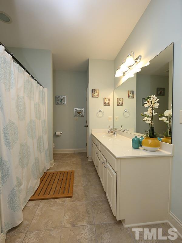 811 Chapanoke Road Raleigh, NC 27603 - Photo 16 of 25 a spacious bathroom with a double vanity sink a mirror and a shower