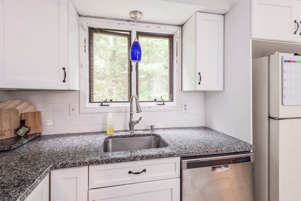 1 Spruce Tree Lane, Unit 3 Norton, MA 02766 - Photo 2 of 18 a kitchen with granite countertop a sink stainless steel appliances white cabinets and a window