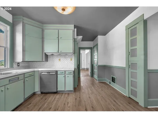 a kitchen with kitchen island granite countertop a sink cabinets and stainless steel appliances