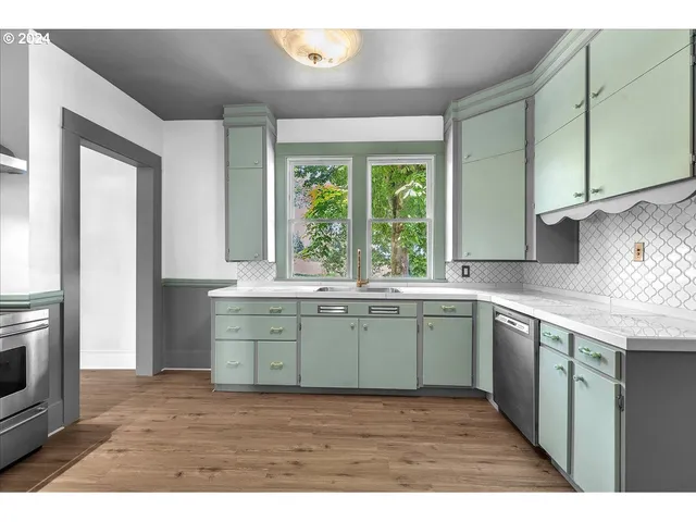 a kitchen with a sink cabinets appliances and a window