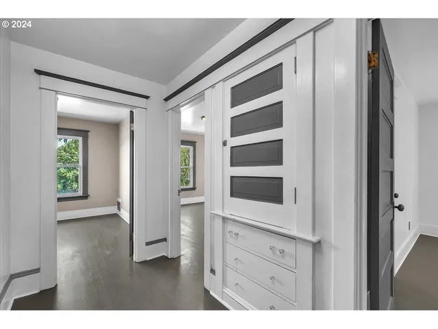 a view of an empty room with cabinet and mirrors