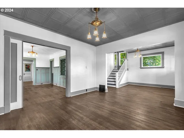 a view of an empty room and window and wooden floor