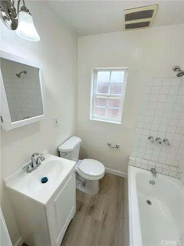 a bathroom with a sink and mirror with toilet