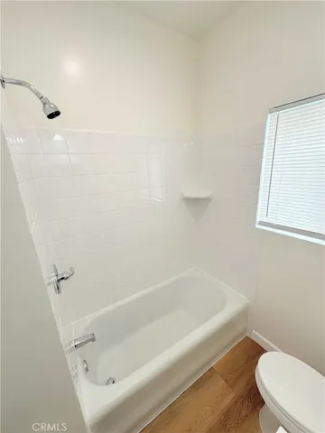 a white bath tub sitting next to a white toilet and a shower