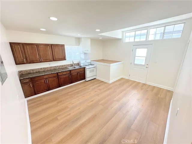 a large white kitchen with a sink a refrigerator and window