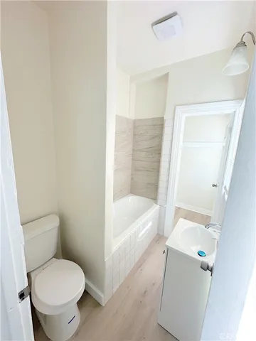 a white toilet sitting next to a bath tub