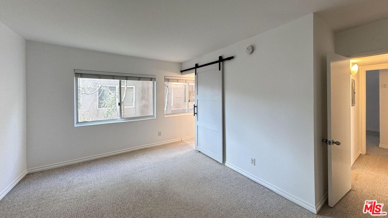 11750 Sunset Boulevard, Unit 317 Los Angeles, CA 90049 - Photo 7 of 11 a view of an empty room with a window