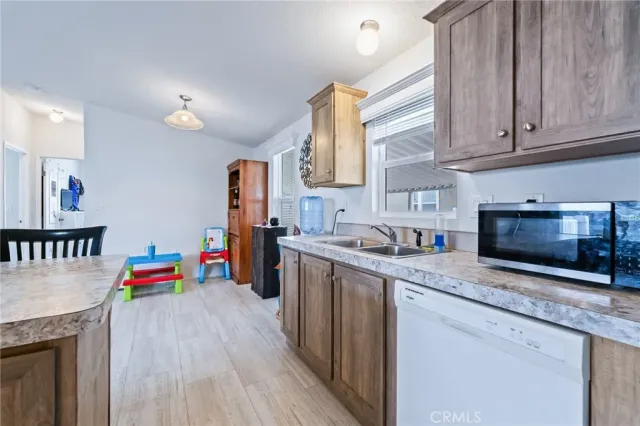 a kitchen with stainless steel appliances granite countertop a sink dishwasher stove top oven and cabinets with wooden floor
