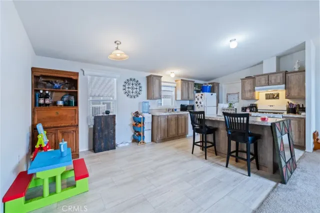 a living room with furniture and a dining table with kitchen view