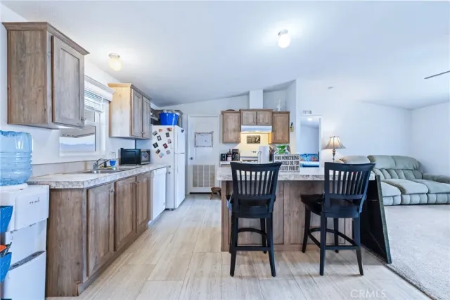 a dining room with stainless steel appliances a kitchen island hardwood floor sink stove dining table and chairs