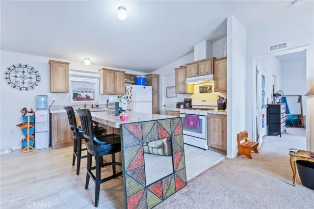 a living room with furniture and a dining table with kitchen view