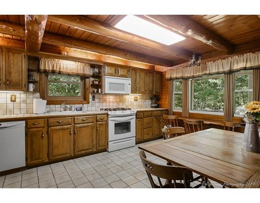 29 Spring Hill Road Newbury, MA 01922 - Photo 9 of 32 a open kitchen with stainless steel appliances kitchen island granite countertop a stove a sink dishwasher and white cabinets with wooden floor