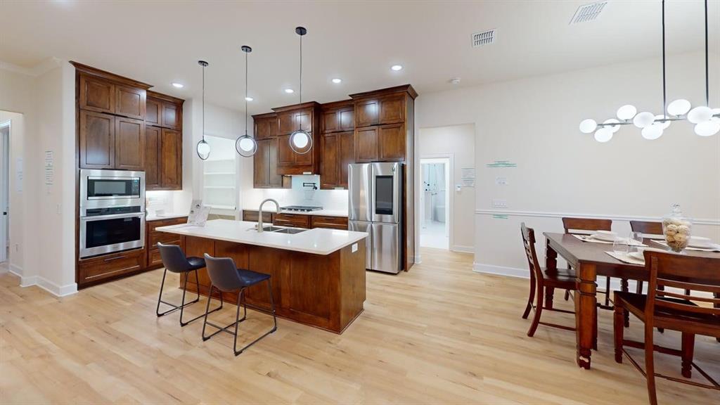 2509 Windmill Lane Longview, TX 75601 - Photo 33 of 35 Kitchen with appliances with stainless steel finishes, light wood-style floors, light countertops, an island with sink, and recessed lighting