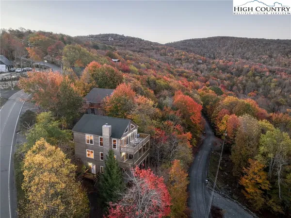 an aerial view of a house with a mountain