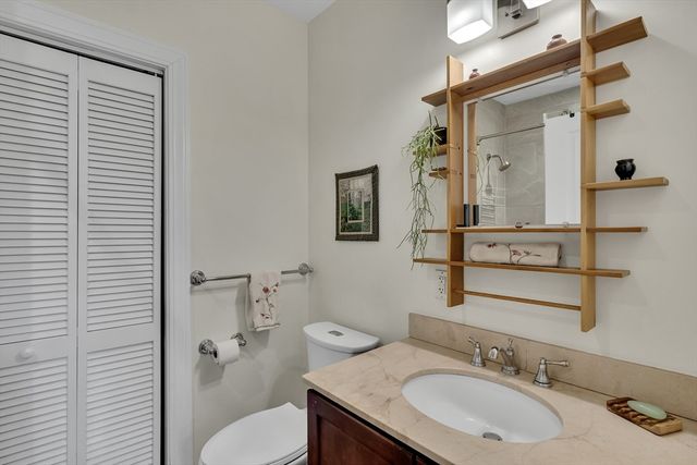 a bathroom with a granite countertop sink toilet and mirror