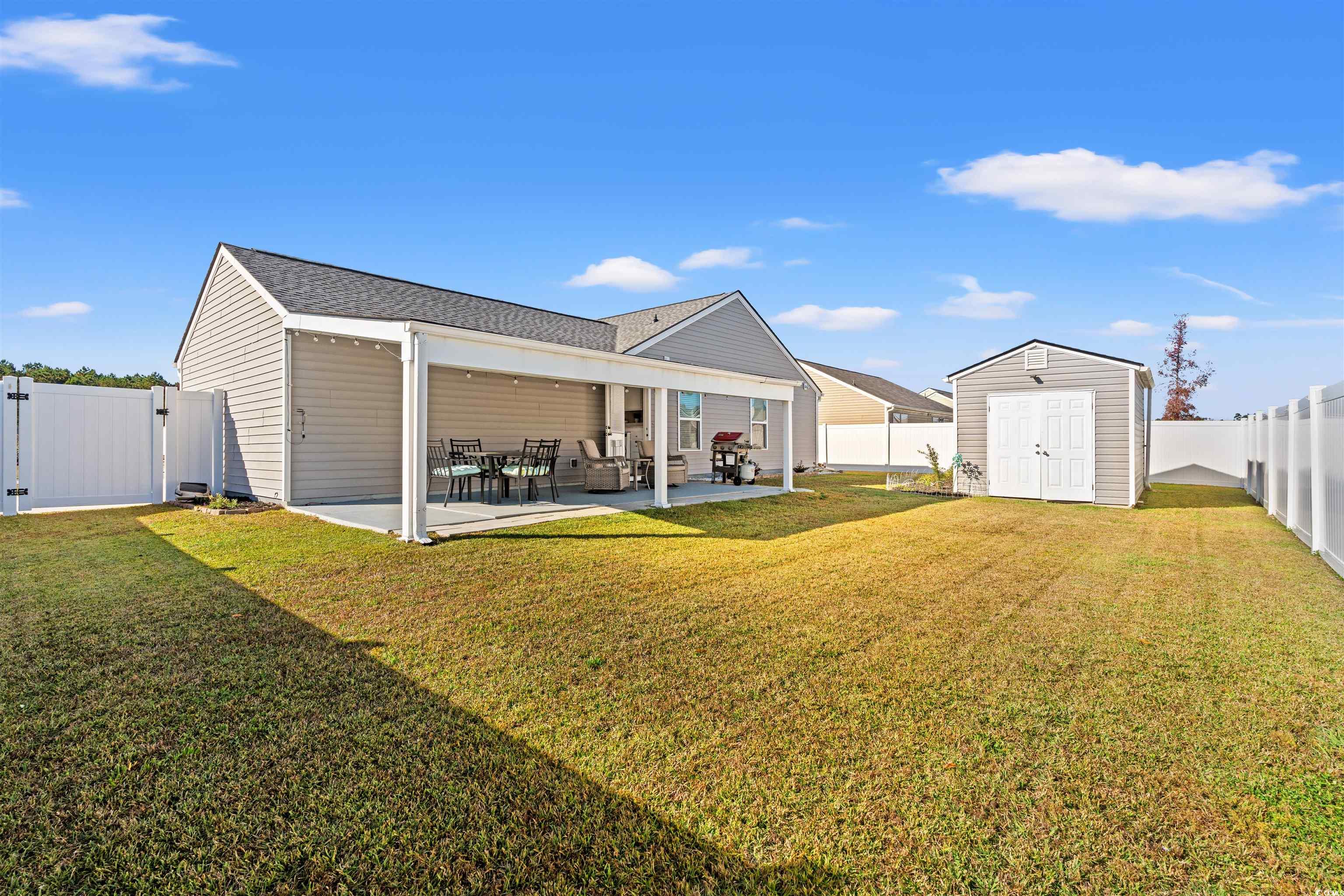 1349 Boker Road Conway, SC 29527 - Photo 19 of 21 Back of property featuring a storage shed, a fenced backyard, a patio, and a gate