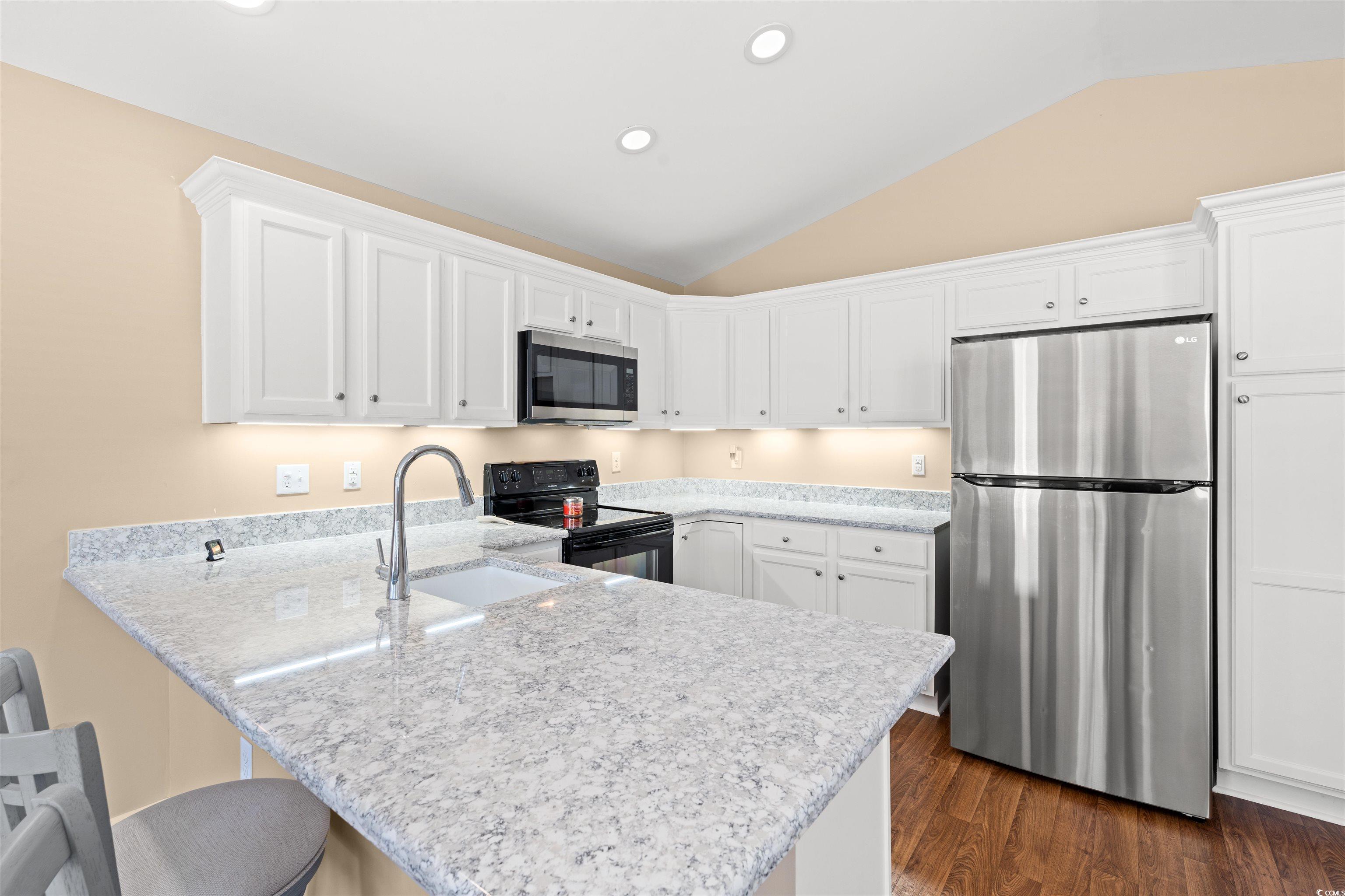 1349 Boker Road Conway, SC 29527 - Photo 4 of 21 Kitchen featuring white cabinetry, stainless steel appliances, lofted ceiling, a peninsula, and a kitchen bar