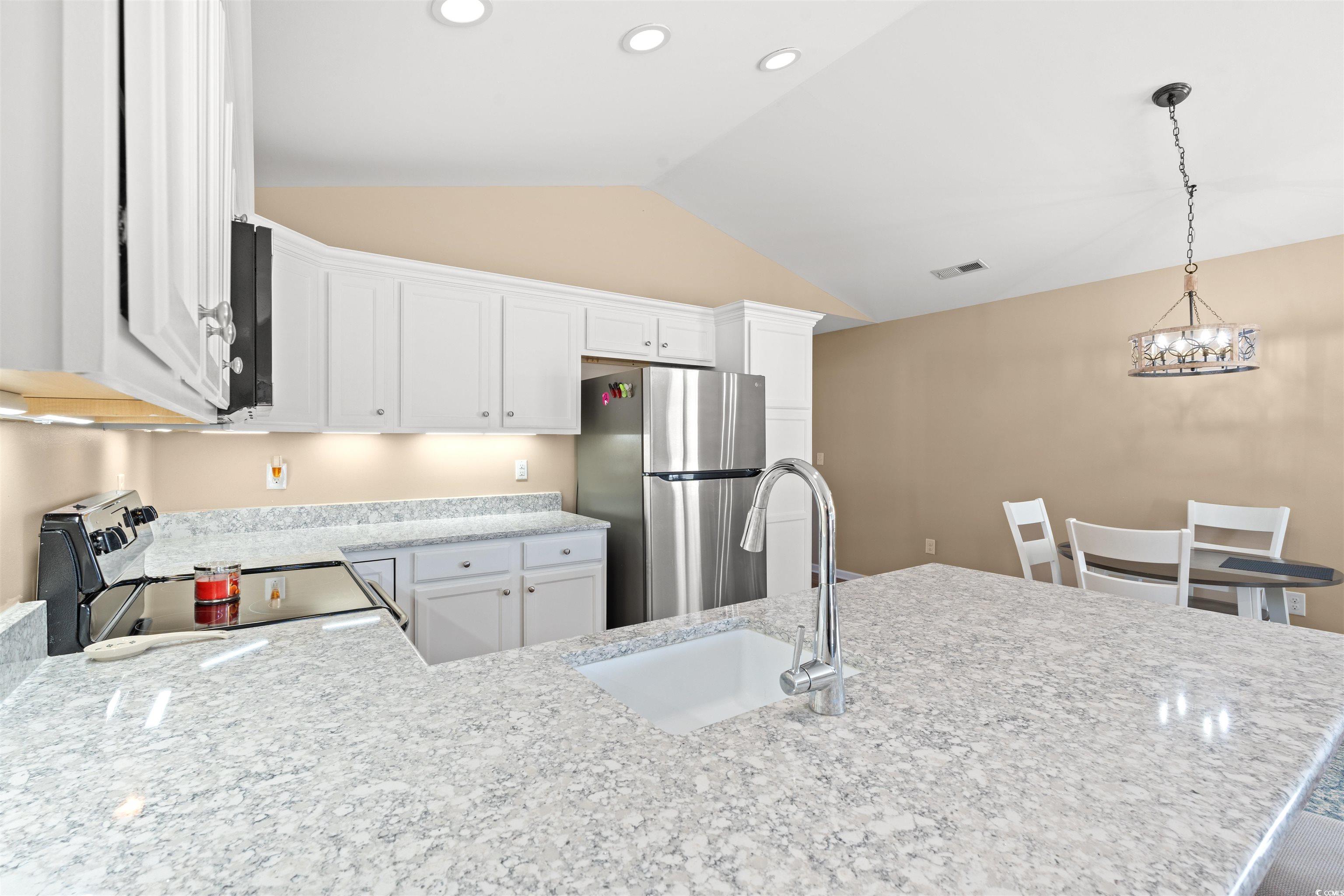 1349 Boker Road Conway, SC 29527 - Photo 6 of 21 Kitchen with freestanding refrigerator, range with electric stovetop, white cabinetry, decorative light fixtures, and light stone counters