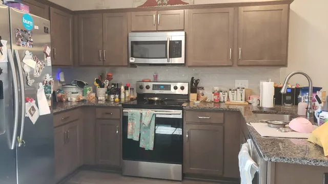 a kitchen with stainless steel appliances granite countertop a refrigerator a stove top oven a sink and dishwasher