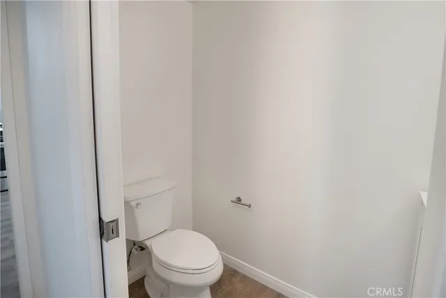 a white toilet sitting next to a white wall