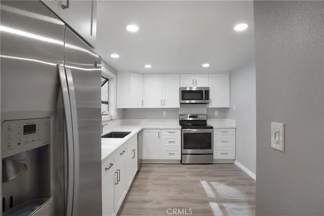 a kitchen with a sink stainless steel appliances and cabinets