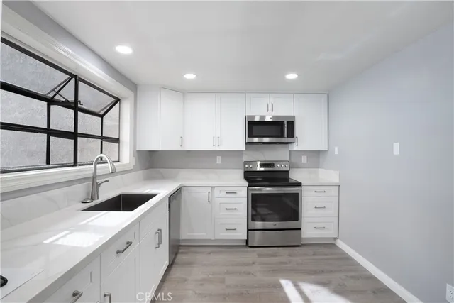 a kitchen with stainless steel appliances granite countertop a sink and a stove