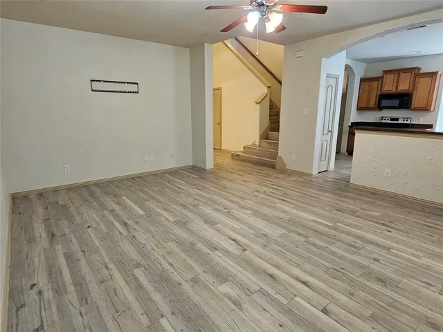 a view of a livingroom with wooden floor and a ceiling fan